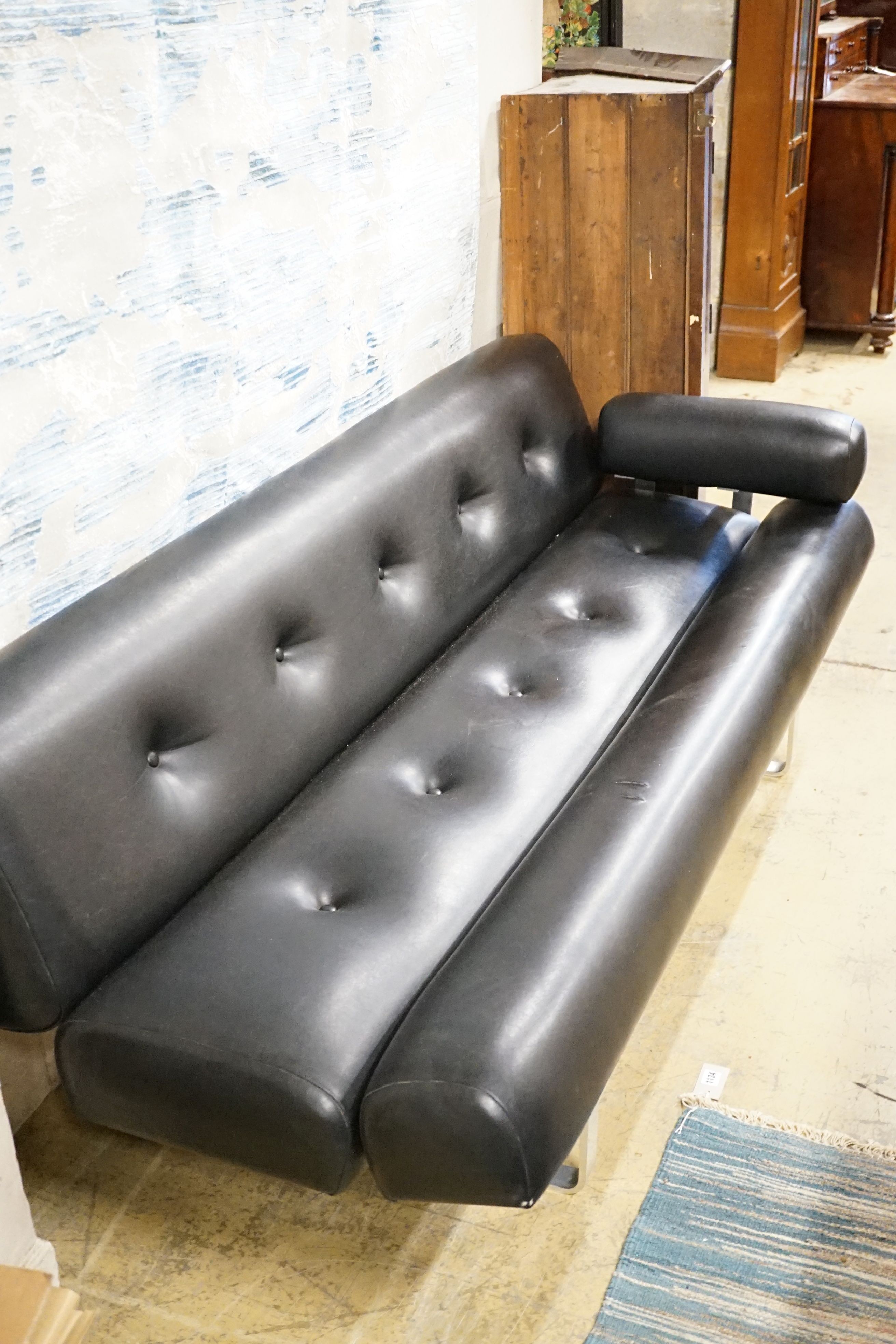 A stylish black vinyl and chrome buttoned settee, by William Plunkett sofa from early 1960s, length 183cm, label on the frame